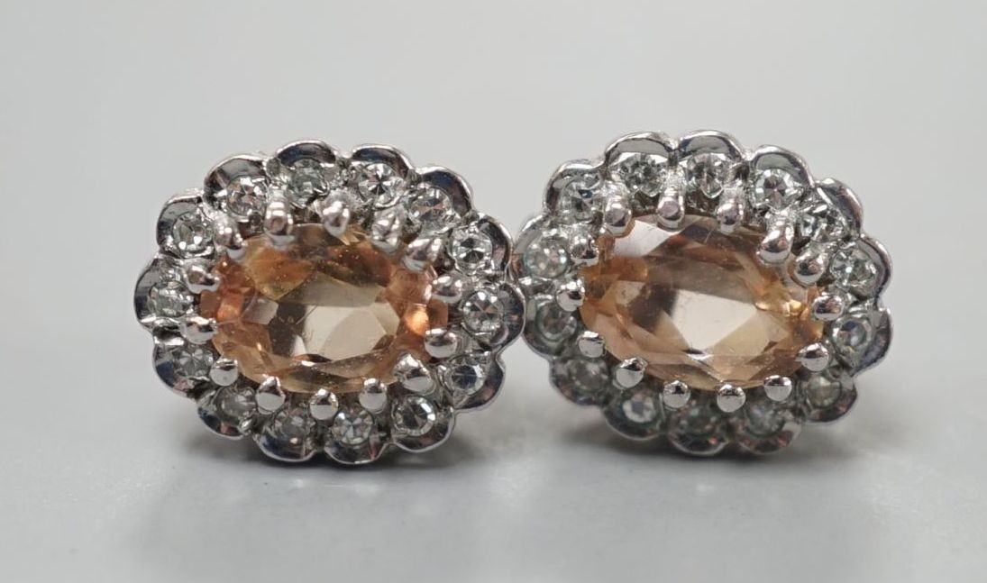 A pair of modern 9ct gold, topaz and diamond set oval cluster earrings, 11mm, gross weight 2.8 grams.